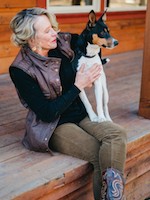 Susan Corning sitting on her porch with a dog.